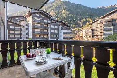 a kitchen with a wooden table with green chairs at Near the slopes of Chamonix-Mont-Blanc - Balcony in Chamonix-Mont-Blanc