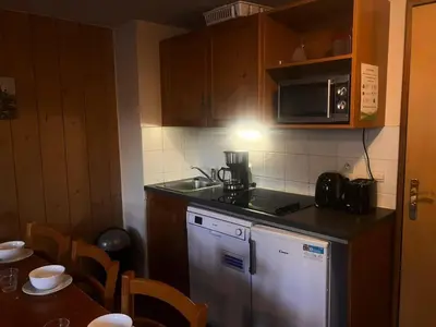 a kitchen with a stove and a microwave and a table at Résidence Les Arolles - Bat Melezes - LES MELEZES - C332 MAE-3363 in Saint-Gervais-les-Bains