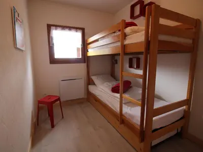 a bunk bed room with two bunk beds and a window at Appartement 2 chambres, pied de piste, parking, 6 personnes - FR-1-836-18 in Arâches-la-Frasse