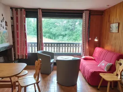 a living room with a red couch and a table at Appartement 2 chambres - 6 pers - Centre station - FR-1-836-17 in Arâches-la-Frasse