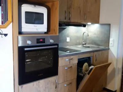 a kitchen with an oven and a microwave and a sink at Appartement 2 chambres - 6 pers - Centre station - FR-1-836-17 in Arâches-la-Frasse