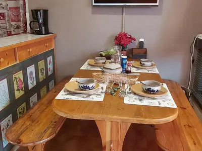 a wooden table with plates and glasses on it at Appartement 2 chambres - 6 pers - Centre station - FR-1-836-17 in Arâches-la-Frasse