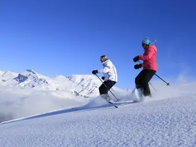 two people are skiing down a snow covered mountain at Appartement 2 chambres - 6 pers - Centre station - FR-1-836-17 in Arâches-la-Frasse