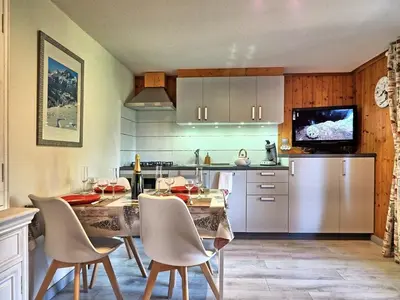 a kitchen with a table and chairs and a kitchen with at Charmant 2 pièces aux Carroz d'Arâches avec parking et WIFI - 4 personnes - FR-1-836-23 in Arâches-la-Frasse