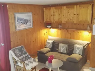a living room with a couch and a chair at Charmant 2 pièces aux Carroz d'Arâches avec parking et WIFI - 4 personnes - FR-1-836-23 in Arâches-la-Frasse
