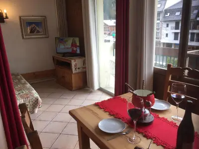 a table with two glasses of wine on top of it at Chamonix Central Panoramic Apartment & Private Sauna in Chamonix-Mont-Blanc