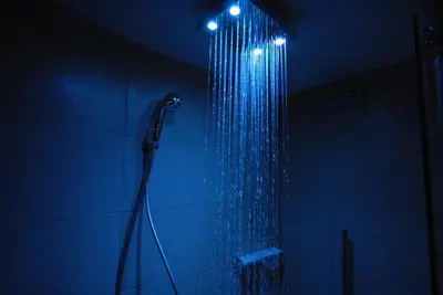 a bathroom with a shower with a blue light at Chamonix Central Panoramic Apartment & Private Sauna in Chamonix-Mont-Blanc