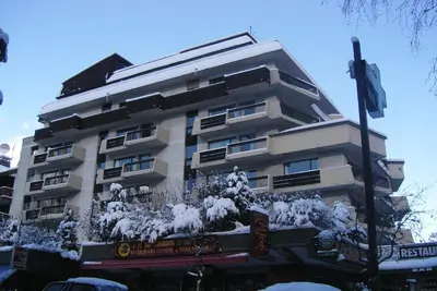 a tall building with snow on it at Chamonix Central Panoramic Apartment & Private Sauna in Chamonix-Mont-Blanc