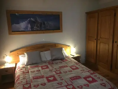 a bedroom with a bed with two lamps and a picture on the wall at Chamonix Central Panoramic Apartment & Private Sauna in Chamonix-Mont-Blanc