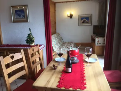 a table with two wine glasses and a christmas tree at Chamonix Central Panoramic Apartment & Private Sauna in Chamonix-Mont-Blanc