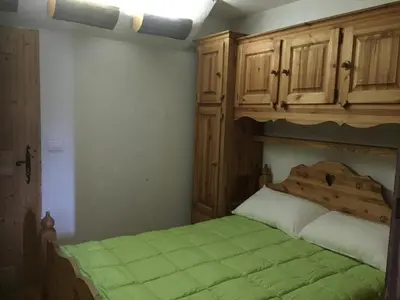 a bedroom with a bed and wooden cabinets at Chamonix Central Panoramic Apartment & Private Sauna in Chamonix-Mont-Blanc