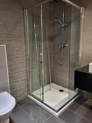 a shower with a glass door in a bathroom at La Sapone et Grange de Bovère in Sixt