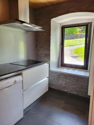 a kitchen with a window and a white counter at La Sapone et Grange de Bovère in Sixt