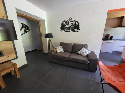 a living room with a couch and a snowboard on the wall at La Sapone et Grange de Bovère in Sixt