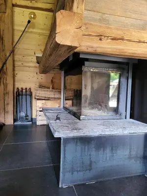a stone bench in a room with a wooden wall at La Sapone et Grange de Bovère in Sixt
