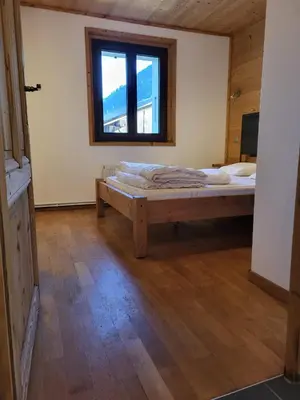 a bedroom with a bed in a room with a window at La Sapone et Grange de Bovère in Sixt