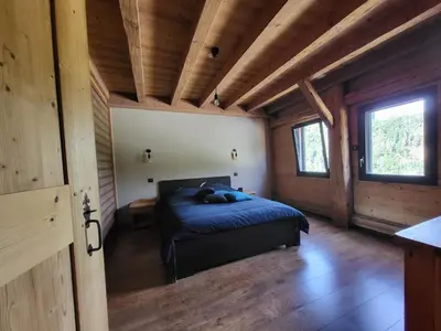 a bedroom with a bed in a wooden cabin at La Sapone et Grange de Bovère in Sixt