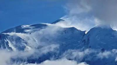 a mountain covered in snow and clouds in the sky at Cristaux Studio, with view to Mont Blanc in Combloux