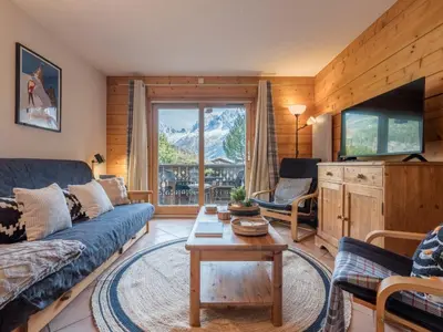 a living room with a couch and a tv at Refuge d'Ian - Close to Ski Piste Prarion - Swimming pool & Gym - By Cozee Rentals in Les Houches