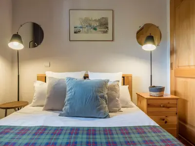 a bedroom with a bed with pillows and two lamps at Refuge d'Ian - Close to Ski Piste Prarion - Swimming pool & Gym - By Cozee Rentals in Les Houches
