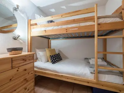 a bedroom with bunk beds with a desk and a bed at Refuge d'Ian - Close to Ski Piste Prarion - Swimming pool & Gym - By Cozee Rentals in Les Houches