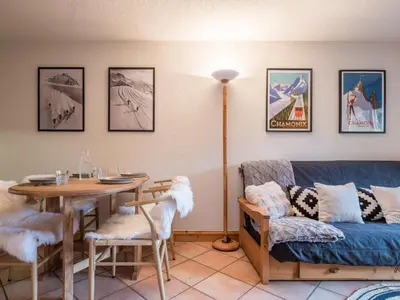 a living room with a table and a couch at Refuge d'Ian - Close to Ski Piste Prarion - Swimming pool & Gym - By Cozee Rentals in Les Houches