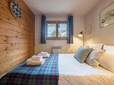 a bedroom with a bed with towels on it at Refuge d'Ian - Close to Ski Piste Prarion - Swimming pool & Gym - By Cozee Rentals in Les Houches
