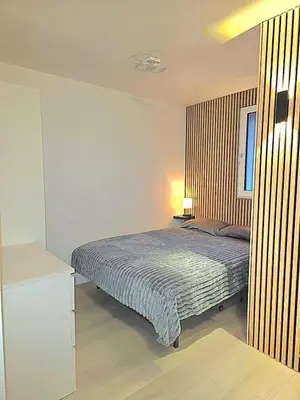 a bedroom with a bed with a blue comforter at Appartement Samoëns 1600 in Samoëns
