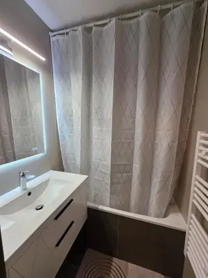 a bathroom with a sink and a shower with a mirror at Appartement Samoëns 1600 in Samoëns
