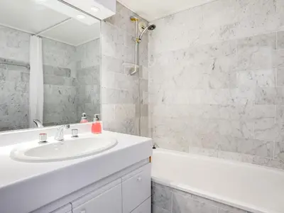 a bathroom with a white sink and a bath tub at Apartment Bel Alp-1 by Interhome in Saint-Gervais-les-Bains