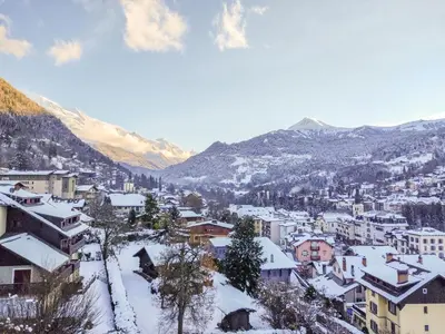 a city covered in snow with mountains in the background at Apartment Bel Alp-1 by Interhome in Saint-Gervais-les-Bains