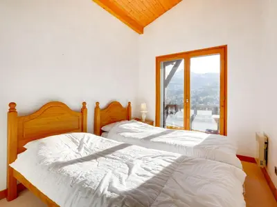 two white beds in a room with a window at Apartment Bel Alp-1 by Interhome in Saint-Gervais-les-Bains