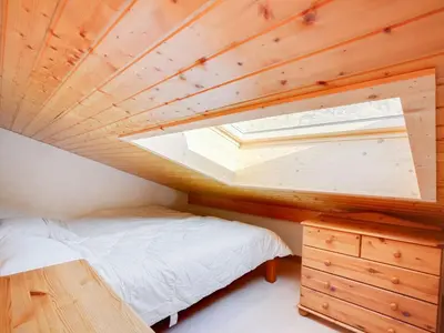 a small bedroom with a bed and a skylight at Apartment Bel Alp-1 by Interhome in Saint-Gervais-les-Bains