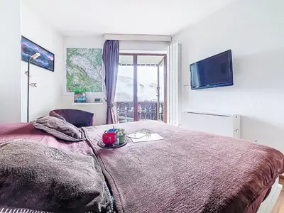 a bedroom with a large bed and a chair at Studio L'aiguille noire by Interhome in Bionnay