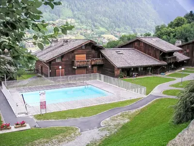 a house on a hill next to a green field at Studio Les Grets-13 by Interhome in Saint-Gervais-les-Bains