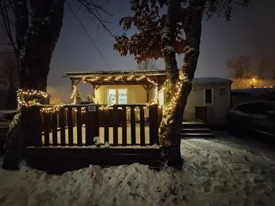 a house with christmas lights on a fence at Joli mobil home tout équipé 4 personnes in Samoëns