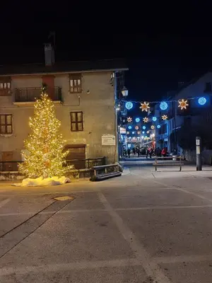 a christmas tree in the middle of a street at night at Joli mobil home tout équipé 4 personnes in Samoëns
