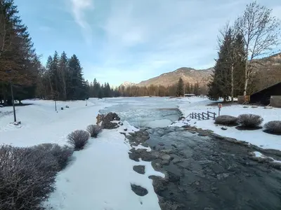 a river with snow on the ground and trees at Joli mobil home tout équipé 4 personnes in Samoëns