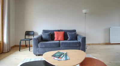 a living room with a blue couch and a table at Apartment Safi in Chamonix-Mont-Blanc