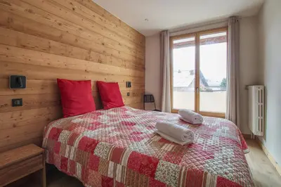 a bedroom with a large bed with red pillows at Apartment Safi in Chamonix-Mont-Blanc
