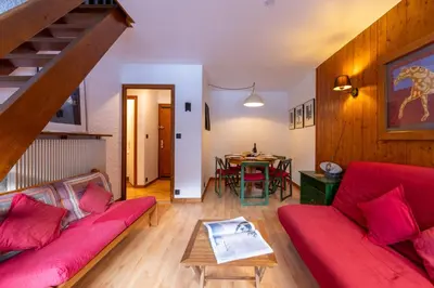 a living room with a red couch and a table at Hautes Aiguilles 29 in Chamonix-Mont-Blanc