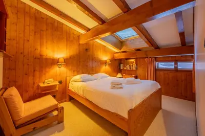 a bedroom with a bed and a chair at Hautes Aiguilles 29 in Chamonix-Mont-Blanc