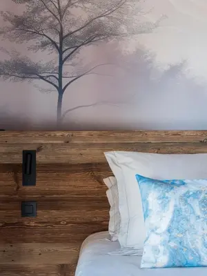 a bedroom with a bed with a tree mural on the wall at Chalet Marianna I Le Chalet Club in Combloux