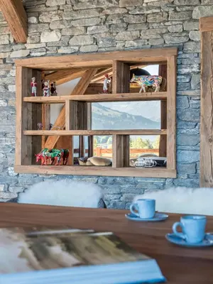 a table with a window in a stone wall at Chalet Marianna I Le Chalet Club in Combloux