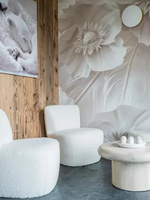 two chairs and a table in front of a wall with flowers at Chalet Marianna I Le Chalet Club in Combloux
