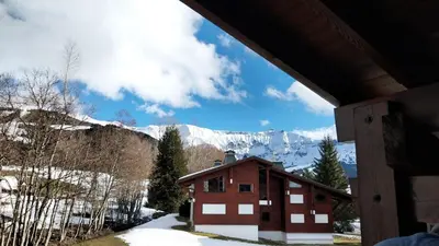 a building with a view of a snow covered mountain at F1 tout confort Megève skis aux pieds in Megève