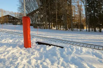 an orange pole in the snow next to a train track at F1 tout confort Megève skis aux pieds in Megève