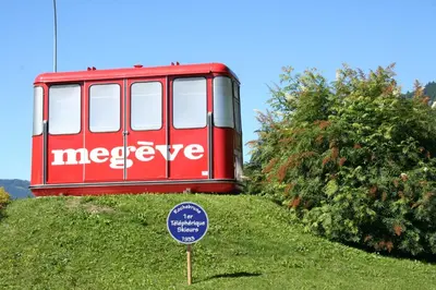 a red bus sitting on top of a hill with a sign at F1 tout confort Megève skis aux pieds in Megève