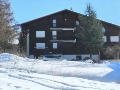a large building with a lot of snow in front of it at F1 tout confort Megève skis aux pieds in Megève