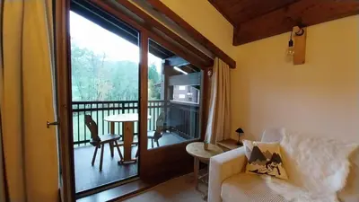 a living room with a view of a balcony at F1 tout confort Megève skis aux pieds in Megève